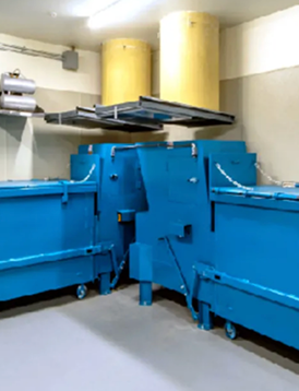 Trash compactor units in a building trash room